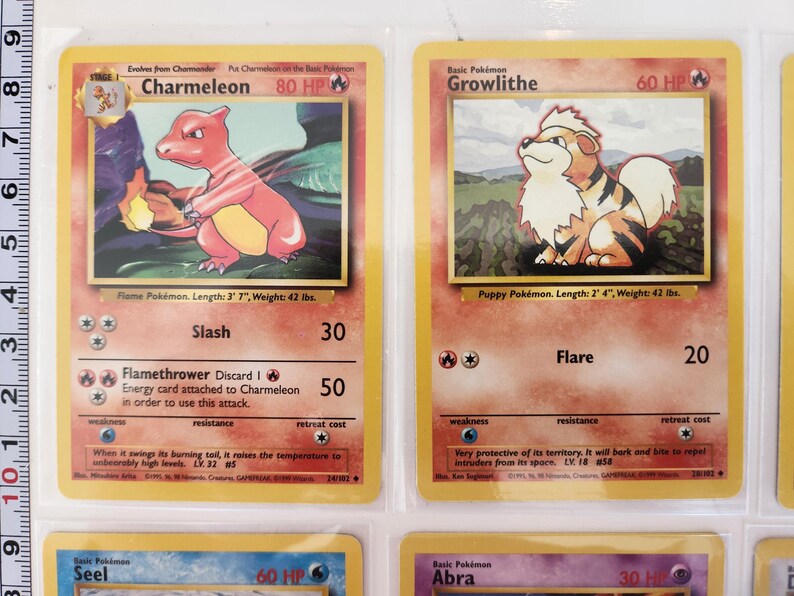 May include: Two vintage Pok&eacute;mon trading cards. One features Charmeleon, a red and yellow flame Pok&eacute;mon, with the text "Flame Pok&eacute;mon. Length: 3' 7", Weight: 42 lbs." The other card shows Growlithe, a puppy Pok&eacute;mon, with the text "Puppy Pok&eacute;mon. Length: 2' 4", Weight: 42 lbs."