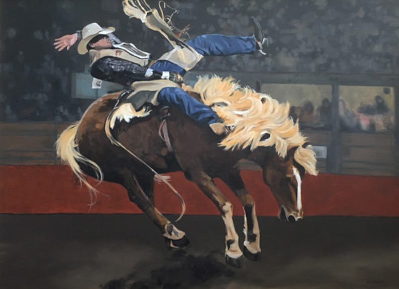 Op de afbeelding: Een cowboy met een bruine hoed en blauwe jeans rijdt op een bruin paard met een blonde manen. Het paard bokt, en de cowboy houdt zich stevig vast. De sc&egrave;ne speelt zich af in een rodeo-arena, met een menigte mensen die toekijken op de achtergrond.