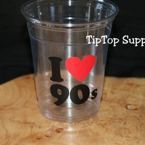 May include: Clear plastic cup with a black and red sticker that says "I love 90's".