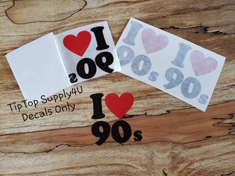 May include: A set of three vinyl decals featuring the text "I love the 90s" with a red heart. The decals are available in black and gray.