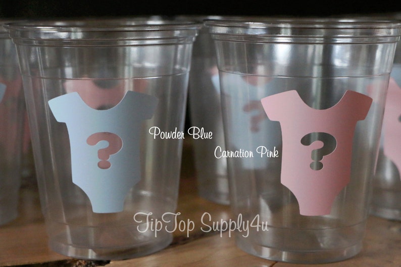 May include: Two clear plastic cups with a question mark inside a baby onesie. The onesie on the left cup is powder blue and the onesie on the right cup is carnation pink. The text "Powder Blue" and "Carnation Pink" is printed below the cups. The text "Tip Top Supply4u" is printed below the cups.