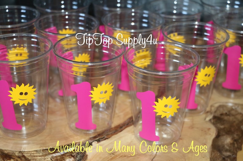 May include: Clear plastic cups with a pink number one and a yellow sun with a smiley face. The text "Tip Top Supply4u" is visible in the image.