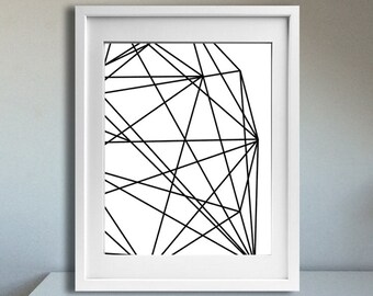 May include: A black and white geometric print in a white frame on a white table with a black lamp. The print features a series of intersecting lines creating a geometric pattern.
