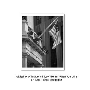May include: A black and white photograph of the New York Stock Exchange building with an American flag waving in the wind.