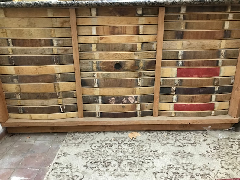 May include: A wooden cabinet with three drawers, each made from reclaimed wine barrel staves. The cabinet has a rustic, farmhouse style and is perfect for adding a touch of vintage charm to any room.