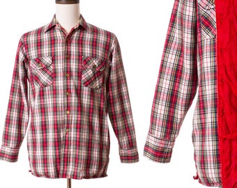 Op de afbeelding: Een rood, wit en zwart geruit overhemd met twee borstzakken en een knoopsluiting. Het overhemd wordt op een mannequin getoond. De binnenvoering is rood.