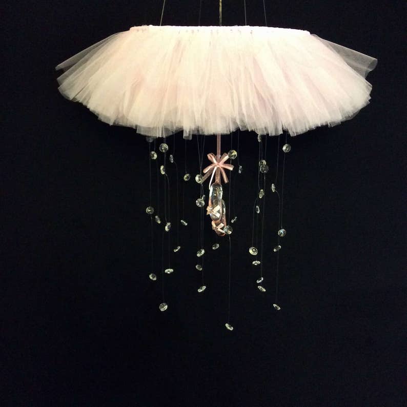 Peut inclure: Un mobile en tulle rose avec un charme de chaussure de ballerine en cristal et des accents de cristal suspendus.