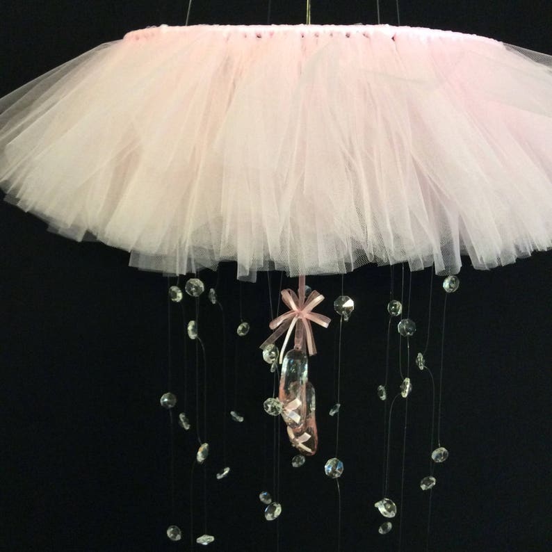 Peut inclure: Un mobile en tulle rose avec un charme de chaussure de ballet rose et des accents de cristal.