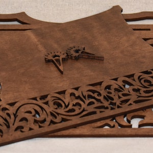 May include: A set of three unfinished wooden pieces with intricate cut-out designs. The pieces are stacked on top of each other and have a brown color.