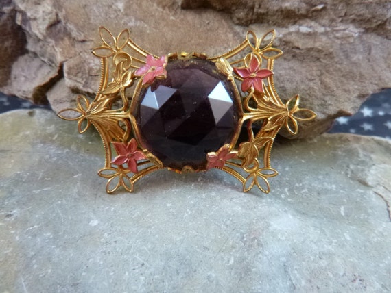 Mid Century Gilded Brooch Large Faceted Purple Glass Stone Surrounded by Pink Flowers and Golden Vines