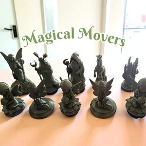 May include: A collection of dark green fantasy figurines, including angels, a wizard, and a horse, arranged on a pink surface. The text "Magical Movers" is displayed in green script above the figurines.