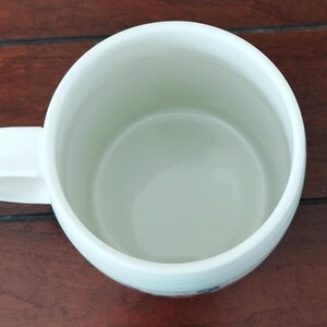 May include: A set of three ceramic mugs with a speckled, matte finish. The mugs are in shades of cream, light brown, and dark brown. Each mug has a simple, minimalist design and a rounded handle. Perfect for coffee or tea.