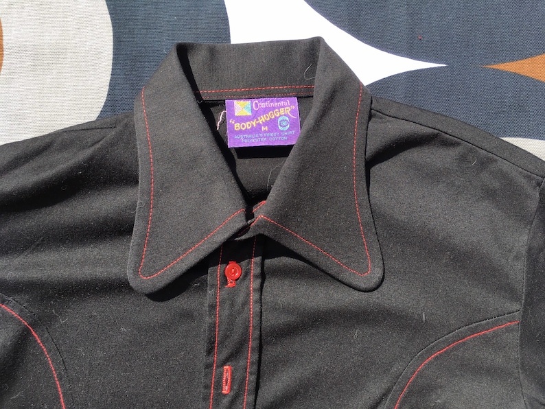 Get down and get FUNKY in this 1970s body-hugging short-sleeve stretch shirt with extra-funky collar and contrast red buttons Medium