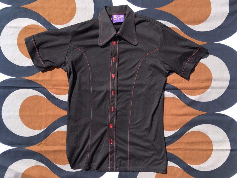 Get down and get FUNKY in this 1970s body-hugging short-sleeve stretch shirt with extra-funky collar and contrast red buttons Medium