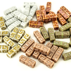 May include: Assortment of ceramic beads with a gold Greek key design. The beads are in four colors: white, brown, light brown, and green.