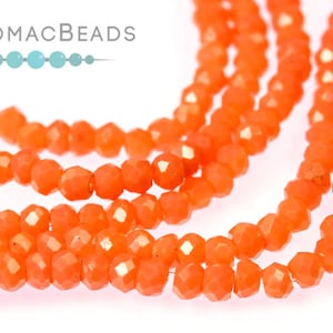 May include: A strand of bright orange faceted glass beads. The beads are small and have a slightly irregular shape.