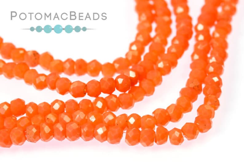 May include: A strand of bright orange faceted glass beads. The beads are small and have a slightly irregular shape.