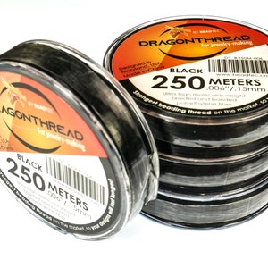May include: A spool of black Dragonthread beading thread for jewelry making. The spool is labeled "Black 250 Meters 006"/1.5mm" and "Strongest beading thread on the market, so you design longer!"