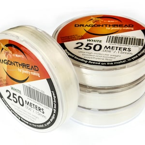 May include: White DragonThread spools for jewelry making. Each spool contains 250 meters of ultra-high molecular weight, braided, and bonded polyethylene fiber. The packaging features the brand name, product details, and the text "Strongest beading thread on the market, so your designs will last longer!"