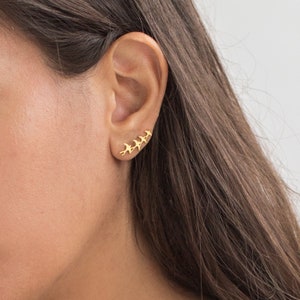 May include: Gold ear cuff with a row of five small bird silhouettes.