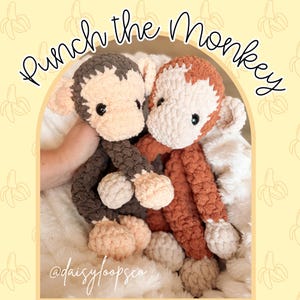 May include: Two handmade crochet monkey plushies. One is brown and cream, the other is orange and cream. The text "Punch the Monkey" is arched above the monkeys. The bottom of the image has the text "@daisyloopsco".