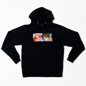 May include: Black hooded sweatshirt with a rectangular graphic featuring two anime characters in a face-off. The graphic includes red, white, green, and brown colors. The sweatshirt has a front pocket and a drawstring hood.