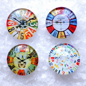 Puede incluir: Cuatro cabujones redondos de vidrio con diferentes diseños de esfera de reloj. Los cabujones son coloridos y presentan varios números, letras y símbolos.