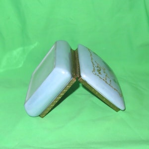 May include: A light blue porcelain trinket box with gold trim and a gold inscription that reads "Our First Christmas Together".