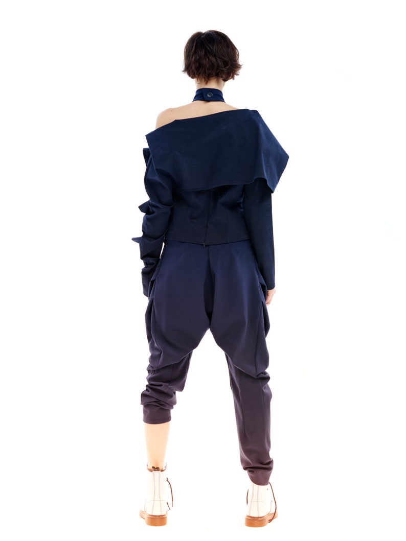 May include: A navy blue off-the-shoulder top with long sleeves and a matching pair of pants. The outfit has a relaxed, casual fit.