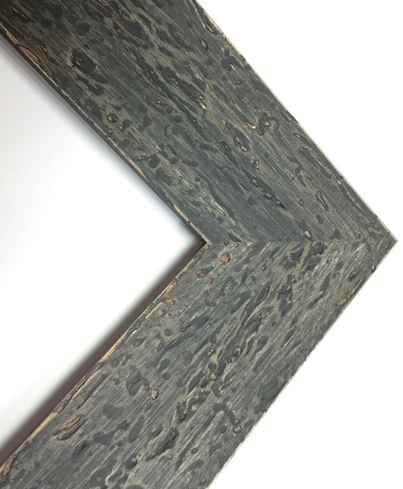 May include: Close-up of a corner of a dark grey wood picture frame with a distressed finish. The frame has a rustic look with knots and grain patterns.