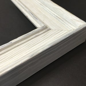 May include: White painted wooden picture frame with a slightly distressed finish. The frame has a simple, classic design with a slightly raised edge.