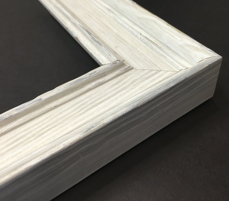 May include: White painted wooden picture frame with a slightly distressed finish. The frame has a simple, classic design with a slightly raised edge.