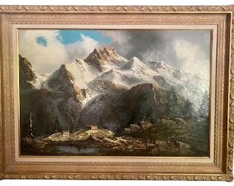 May include: A framed oil painting depicting a snow-capped mountain range with a small lake in the foreground. The mountains are painted in shades of brown, gray, and white, with a hint of blue in the sky. The painting is framed in a gold-colored frame.
