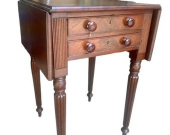 May include: A mahogany drop-leaf table with two drawers and turned legs. The table has a rich brown finish and is in good condition.