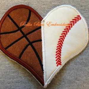 May include: A heart-shaped patch with a basketball on one half and a baseball on the other half. The basketball is brown with black stitching. The baseball is white with red stitching. The text "Bella Bleu Embroidery" is visible in the centre of the patch.