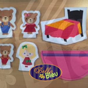 Op de afbeelding: Vingerpoppen van vilt van een berenfamilie, inclusief een moeder, vader en kind, samen met een bed en een roze zak.