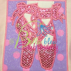 May include: Pink sparkly ballet shoes with a pink ribbon on a purple background with white polka dots. The text "Bella Bleu Embroidery" is visible in the image.