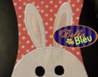 May include: A pink and white polka dot fabric bunny-shaped garment bag with a white bunny face and pink ears. The bag has a hanger loop at the top.