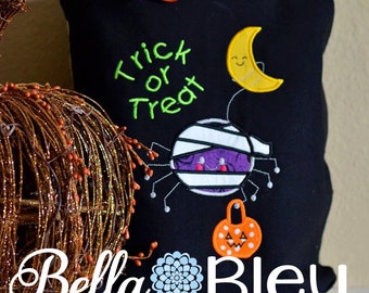 May include: Black Halloween trick or treat tote bag with an embroidered mummy spider, a crescent moon, and a pumpkin. The bag has a white bow with black polka dots.