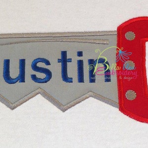 May include: A gray saw-shaped design with the name "Austin" in blue lettering. The saw handle is red and has a white circle on each side.
