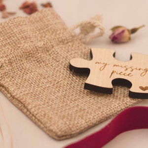 May include: A wooden puzzle piece with the text "my missing piece" and a small heart carved into the wood. The puzzle piece is sitting on a burlap bag.