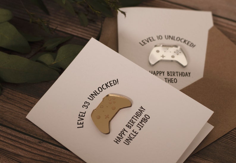 May include: A white card with the text "Level 33 Unlocked!" and a gold-colored video game controller. The card also says "Happy Birthday Uncle Jimbo".