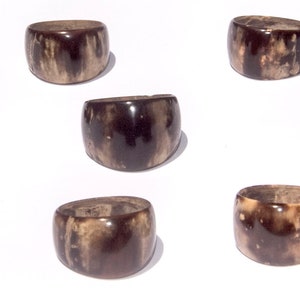 Könnte beinhalten: Acht braune und weiße Hornringe. Die Ringe sind alle in verschiedenen Größen und Formen, aber sie haben alle ein ähnliches Muster aus braunen und weißen Streifen.