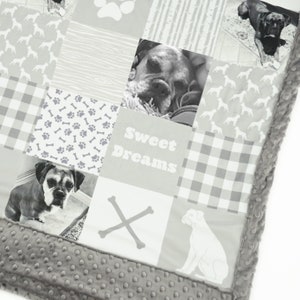 May include: A gray and white patchwork quilt with a dog theme. The quilt features images of dogs, paw prints, bones, and the text "Sweet Dreams".