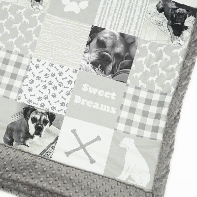 May include: A gray and white patchwork quilt with a dog theme. The quilt features images of dogs, paw prints, bones, and the text "Sweet Dreams".