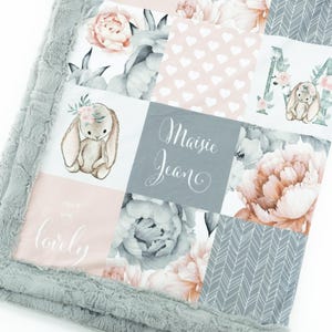 May include: A grey and pink patchwork baby blanket with a floral design, a bunny, and the name "Maisie Jean" written in cursive.