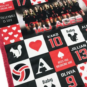 May include: A personalised baby blanket with a team photo and volleyball graphics. The design includes red and white hearts, a volleyball, and the text "14U ACES". The blanket has a red border and a soft texture.
