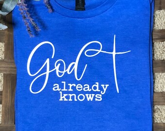 May include: A royal blue t-shirt with white text that reads "God already knows".