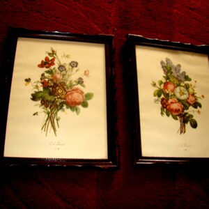 May include: Two framed botanical prints with bouquets of flowers. The print on the left features a bouquet of pink, red, and white flowers with green leaves. The print on the right features a bouquet of purple, white, and pink flowers with green leaves.