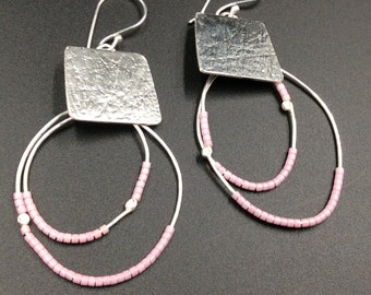 May include: Silver earrings with a textured square charm and two rows of pink beads.